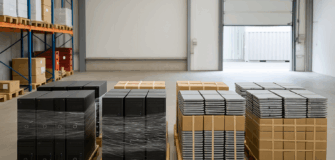 Bild mit 8 Paletten in einer Lagerhalle. Auf den Paletten verpackt sind PC-Komplettsysteme und darauf liegen Laptops. Allerdings sind diese nicht als solche zu erkennen.